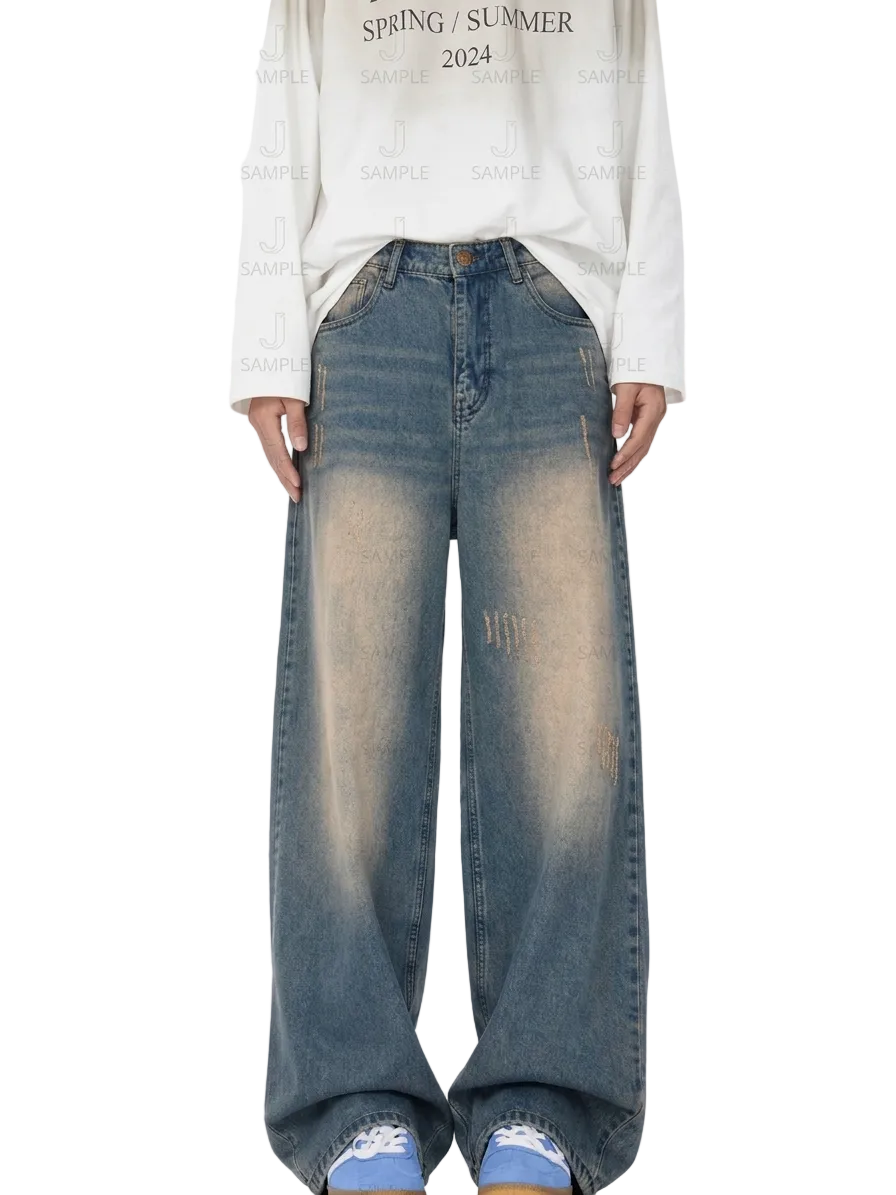 A person wearing wide-leg faded blue denim jeans with a white long-sleeve shirt and blue sneakers, standing against a white background with a repeating watermark pattern.