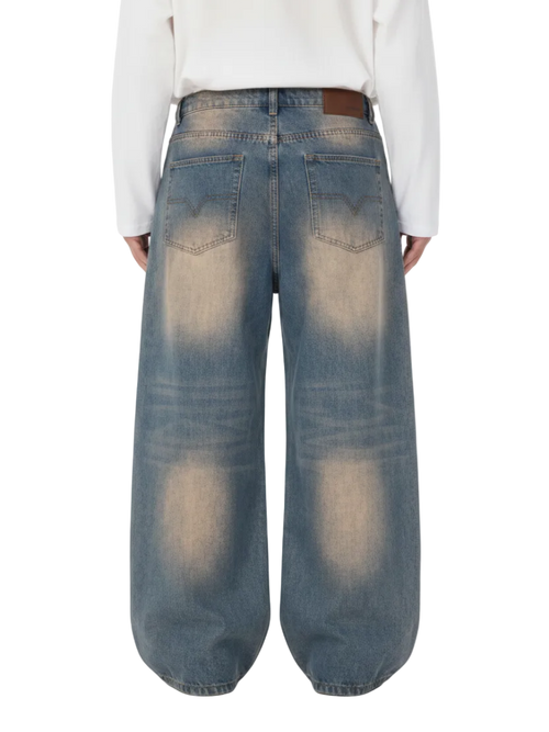 A person shown from the back wearing very wide-leg faded blue denim jeans with a white long-sleeve top. The image has a light gray background with a repeating 'SAMPLE' watermark and 'SPRING / SUMMER 2024' text at the top.